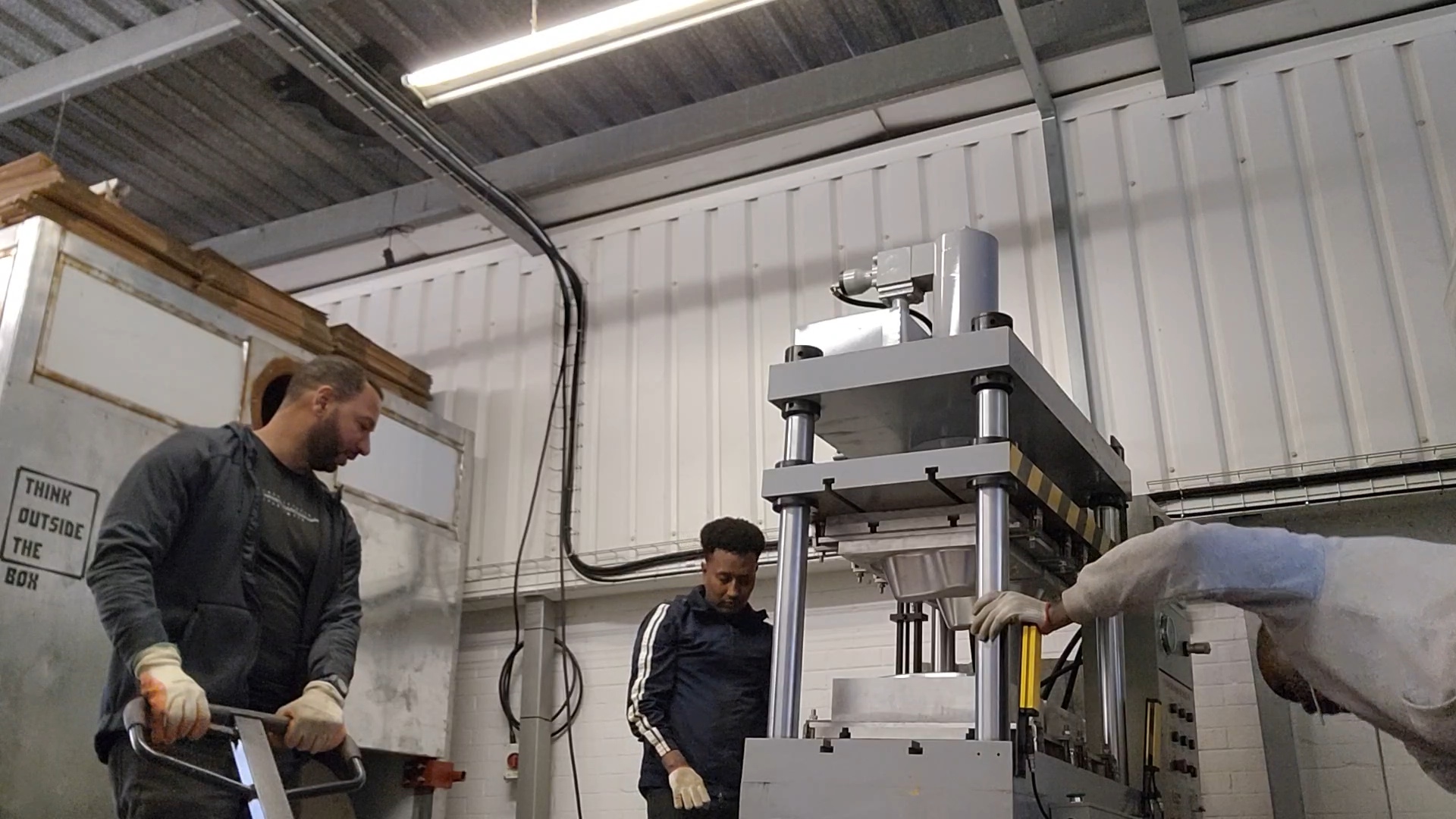 Khaled Alshaheen working with his team beside manufacturing equipment